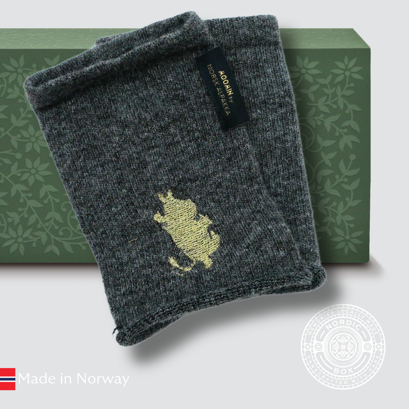 Soft grey alpaca wrist warmers with embroidered © Moomin Troll, crafted in Sigdal by Norsk Alpakka. Warm, sustainable, and Scandinavian elegance.